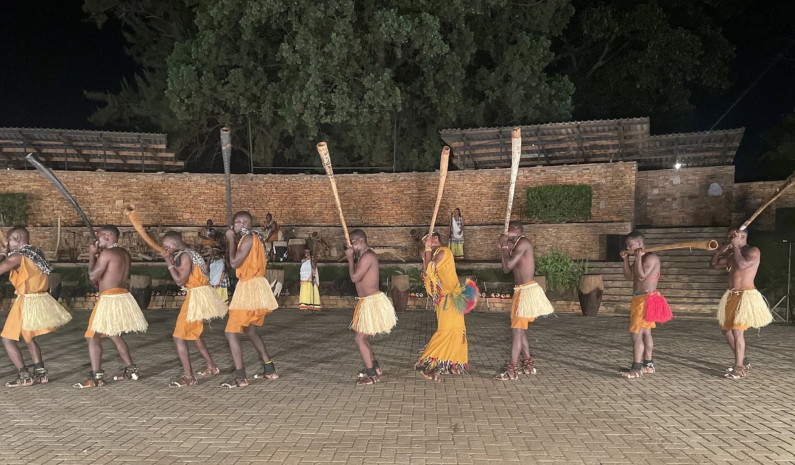 An ensemble performs with long wind instruments at the Ndere Cultural Center in Uganda.