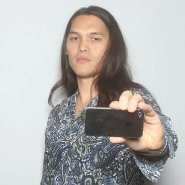 A person holds a smartphone out in front of them to record a scene.